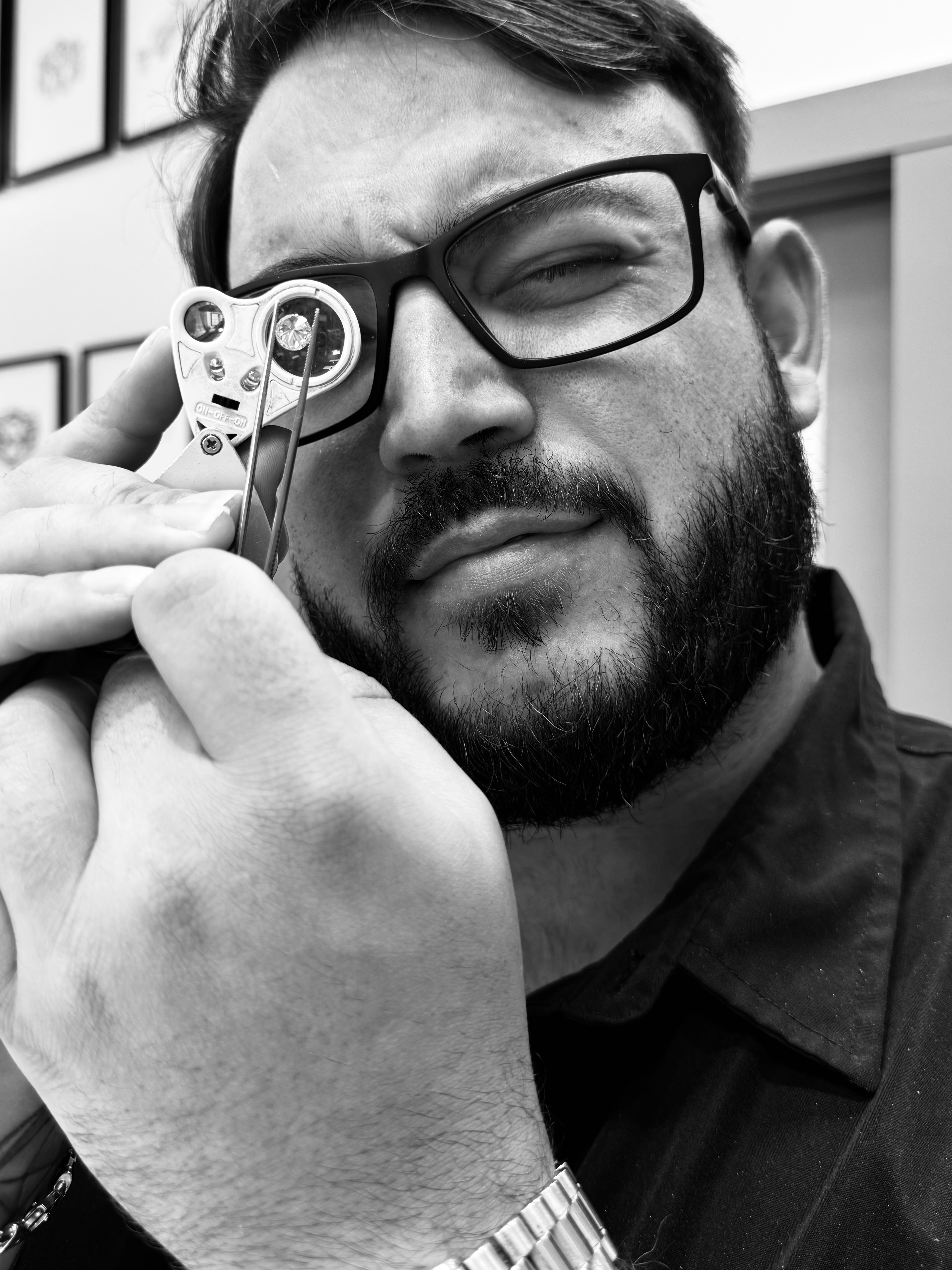 Kyle LaProva closely inspecting a diamond through a jeweler's loupe