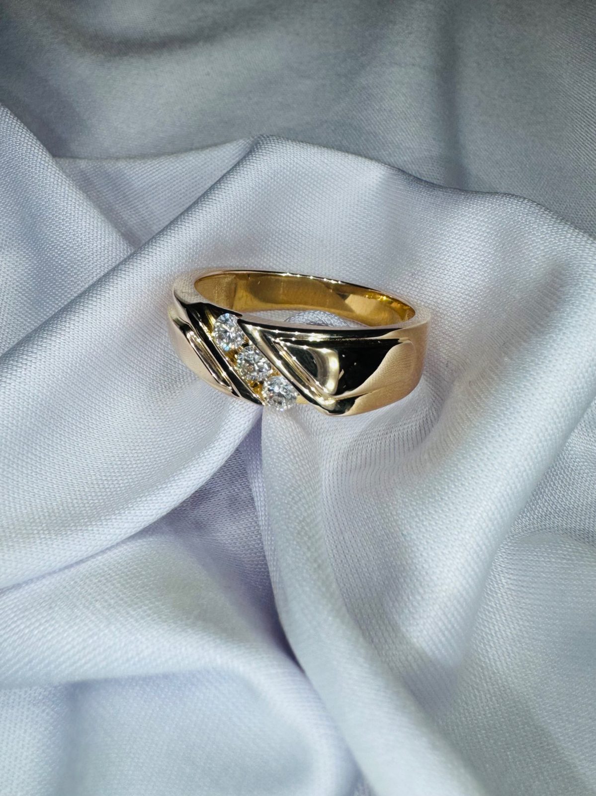 Men's yellow gold band with three round diamonds set on a diagonal