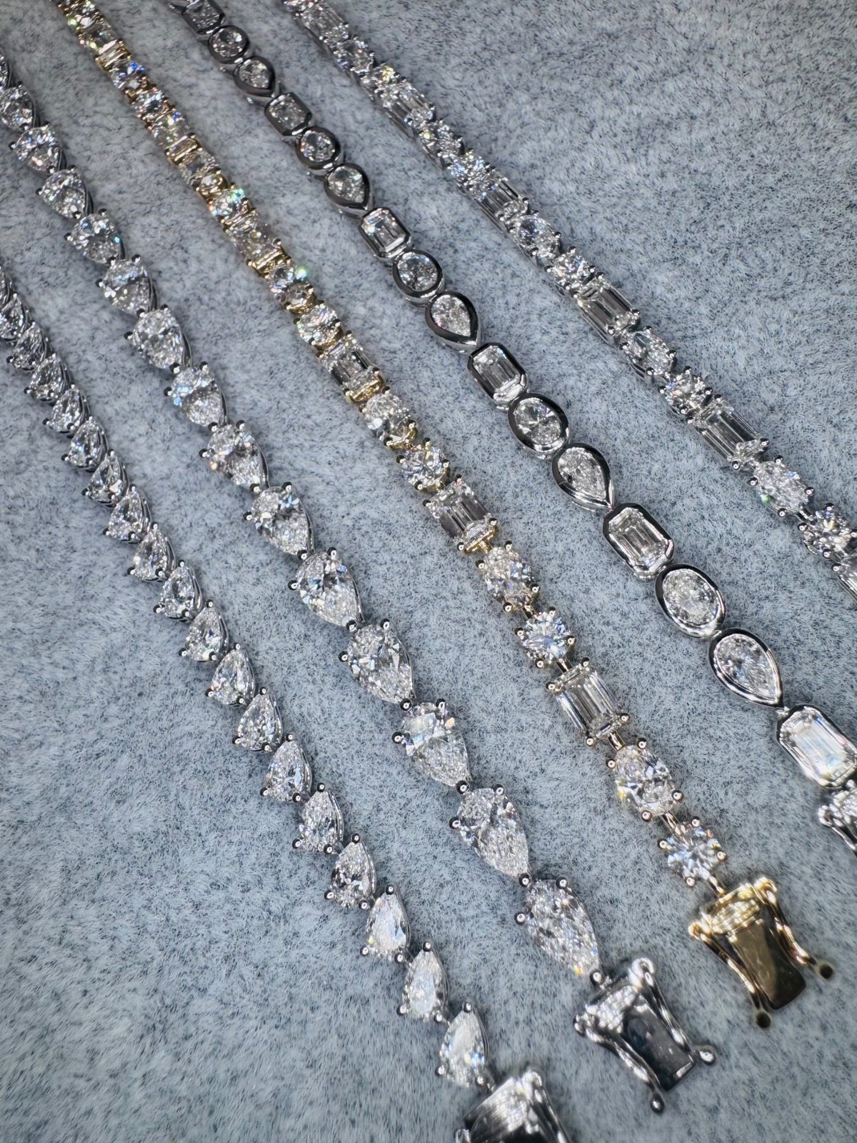 Diamond tennis bracelets in pear, oval, and emerald cuts