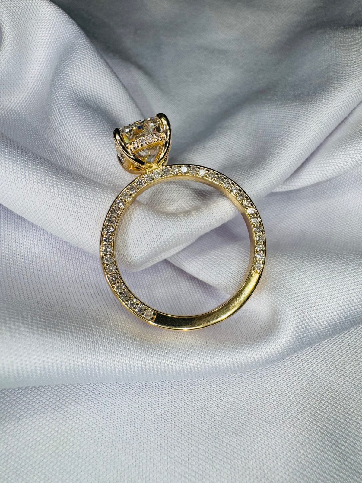 Profile of a yellow gold solitaire with a fully pavé-set band